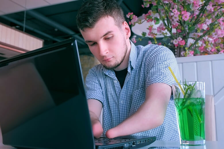 Male amputee using laptop.