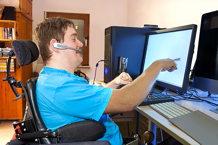 Man with cerebal palsy using a computer.